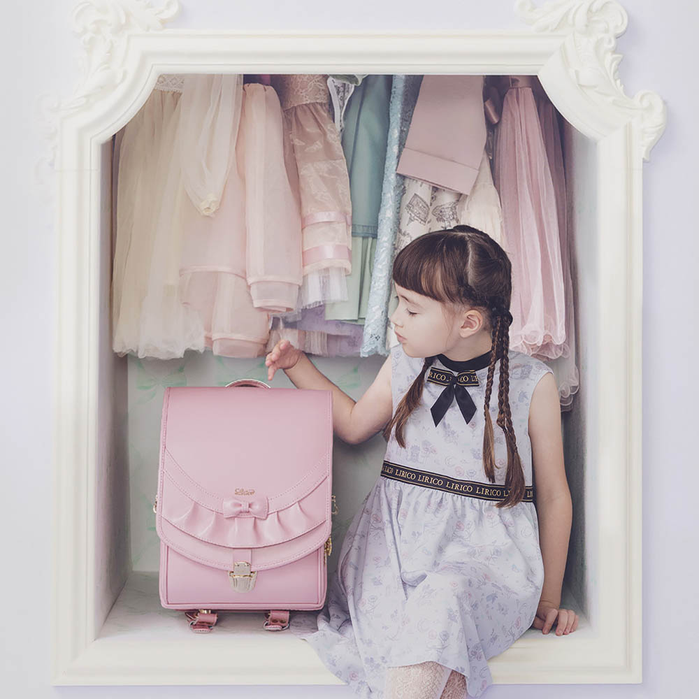 ランドセル リボンフリル パウダーピンク 半かぶせタイプ リリコ かぶせに大胆にあしらわれたフリル、センターに置かれた可憐なリボン ぎゅっと抱きしめたくなる女の子ランドセル