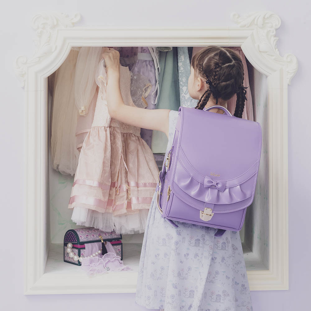 ランドセル リボンフリル シルキーパープル 半かぶせタイプ リリコ かぶせに大胆にあしらわれたフリル、センターに置かれた可憐なリボン ぎゅっと抱きしめたくなる女の子ランドセル