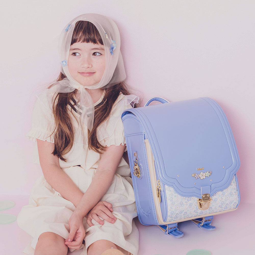 ランドセル ロメリア アイシングブルー 半かぶせタイプ リリコ 花びらの形のかぶせ 花々と輝くストーンの調べが奏でる可憐な女の子ランドセル