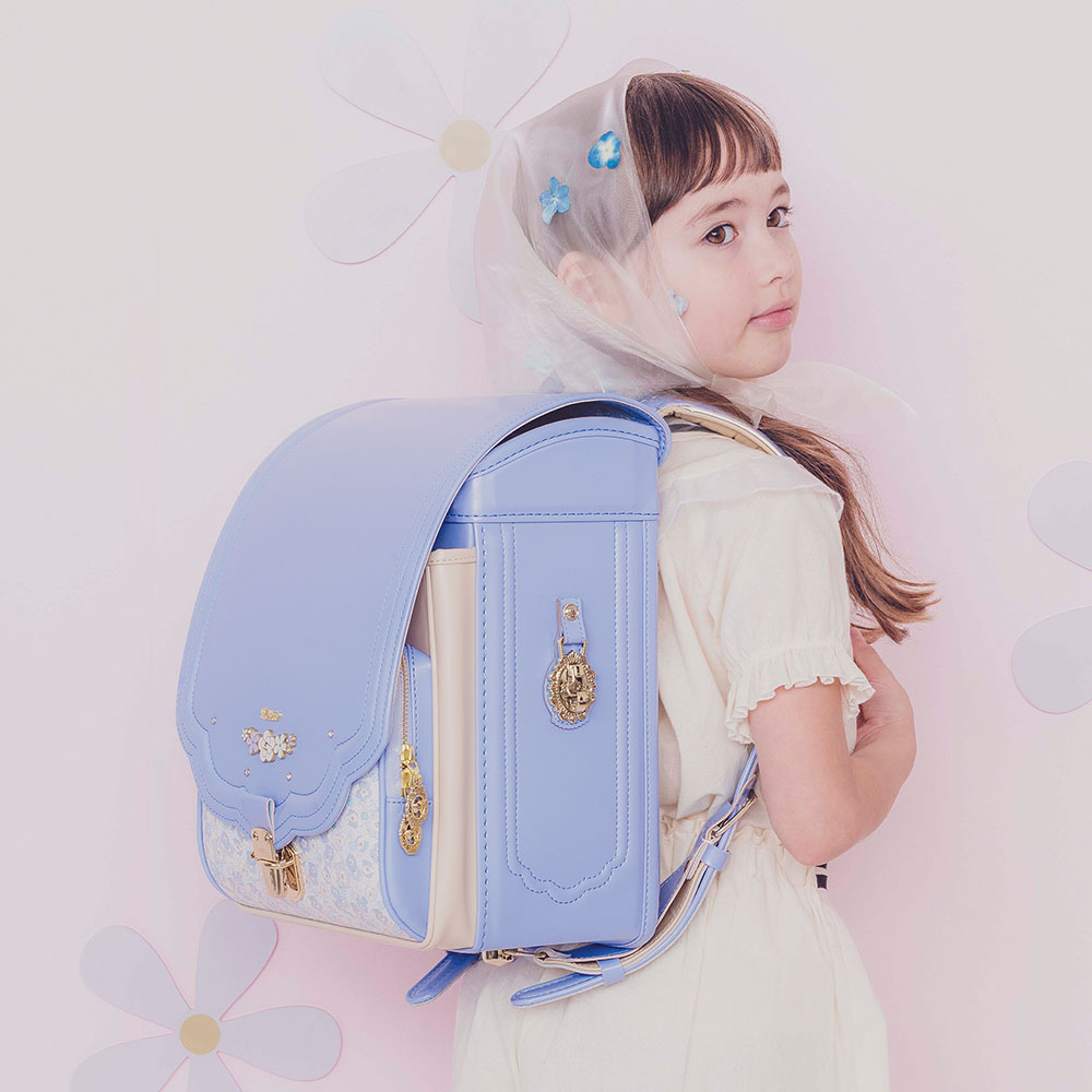 ランドセル ロメリア アイシングブルー 半かぶせタイプ リリコ 花びらの形のかぶせ 花々と輝くストーンの調べが奏でる可憐な女の子ランドセル