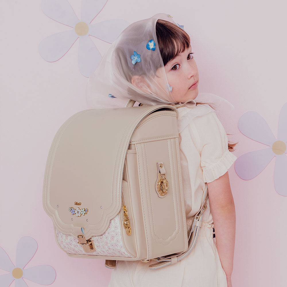 ランドセル ロメリア クリームアイボリー 半かぶせタイプ リリコ 花びらの形のかぶせ 花々と輝くストーンの調べが奏でる可憐な女の子ランドセル