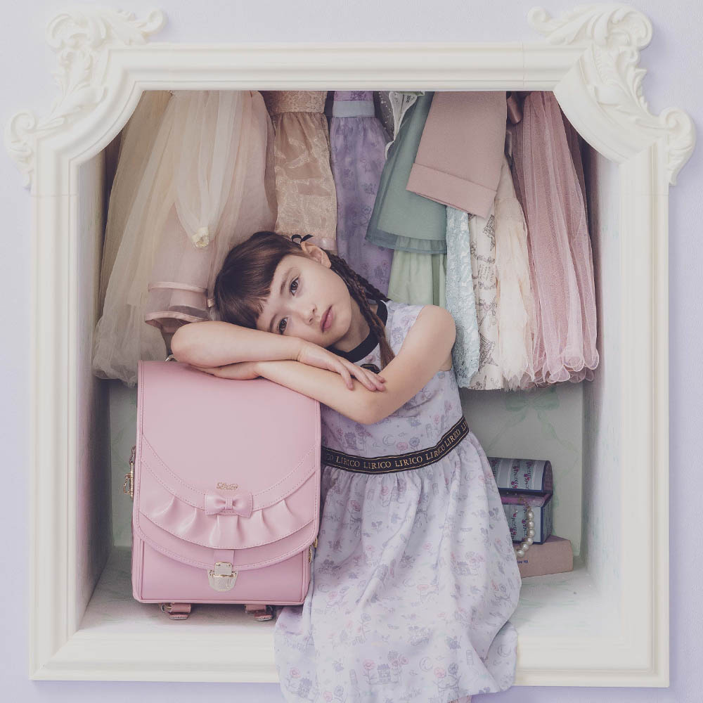 ランドセル リボンフリル パウダーピンク 半かぶせタイプ リリコ かぶせに大胆にあしらわれたフリル、センターに置かれた可憐なリボン ぎゅっと抱きしめたくなる女の子ランドセル